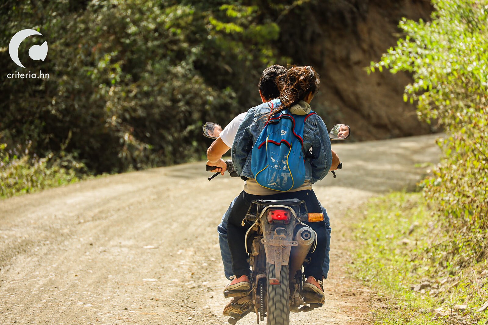 hombre y mujer en moto residente de locomapa en calle de tierra